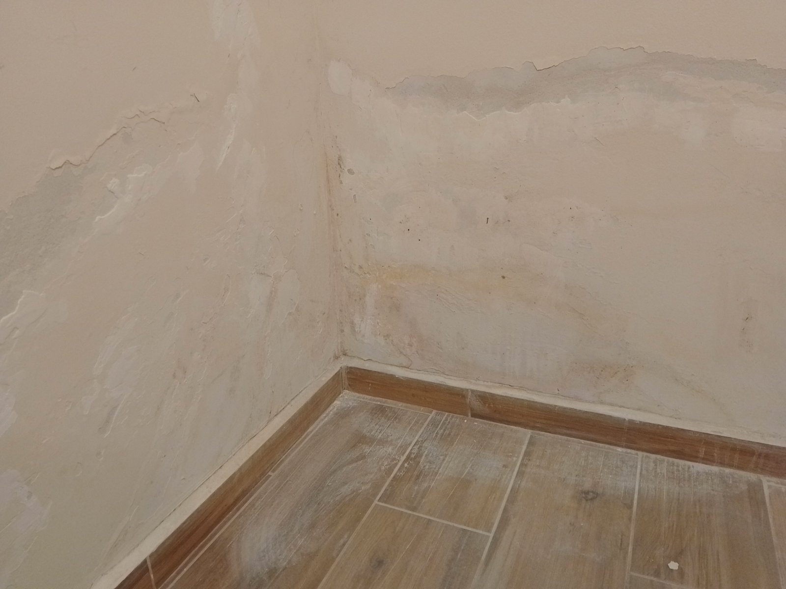 Старые водяные разводы на стене многоквартирного дома после коммунальной аварии, повреждение отделочных материалов и необходимость профессиональной просушки помещений.